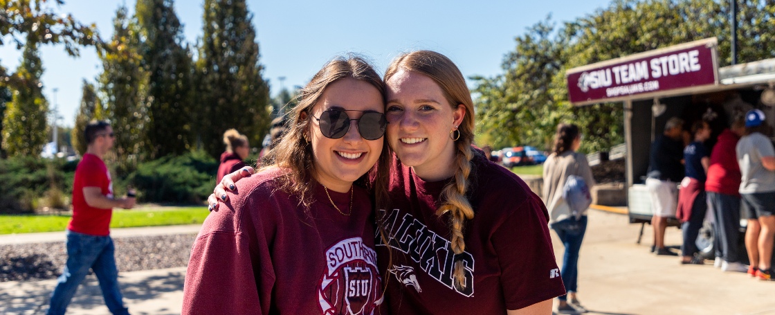 two girls smiling at the Homecoming tailgate